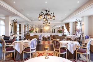 尚蒂伊奥伯格杜迪鲍米酒店的一间带桌椅和吊灯的餐厅