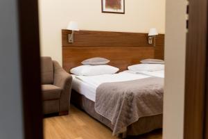 可罗日采奥斯塔尼克酒店的一间卧室配有两张床和椅子