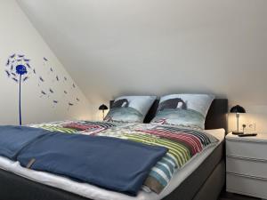 FedderwardersielAm Kutterhafen 17 - HAFENGLÜCK的一间卧室配有两张带蓝色棉被的床