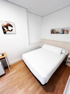 圣塞瓦斯蒂安瑞吉尔旅馆的白色卧室配有床和桌子