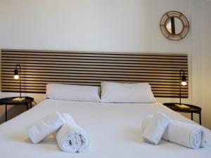 萨拉戈萨Apartamentos El Pilar Suites 3000的卧室配有白色床和毛巾