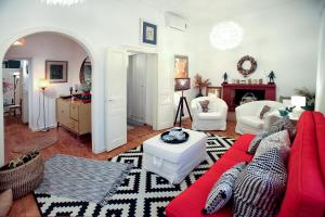 达西亚The Red House in Dassia的客厅配有红色和白色的沙发和壁炉