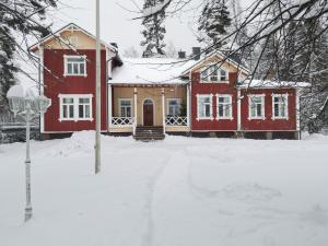 艾赫泰里Inhan Kartano的雪中的一个红色房子,有院子
