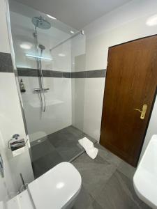 圣奥古斯丁Hotel Regina的带淋浴和卫生间的浴室以及木门。
