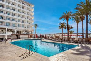 普拉亚登博萨Hotel Vibra Algarb的棕榈树酒店前的游泳池