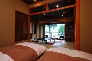 富士河口湖拉库玉旅馆的一间卧室设有两张床,享有庭院的景色