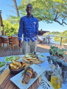 利文斯顿Zambezi Dusk的站在餐桌前的人