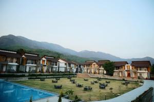 兰纳加Evara Spa & Resort的一座带游泳池的度假村,部分建筑和山脉