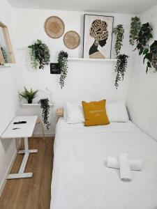 马德里Habitación Callao的白色卧室配有床、桌子和植物
