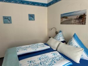 瓦尔内明德Haus Troja的一张带蓝色和白色床单及枕头的床