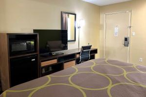 拉法叶拉斐特速8酒店的酒店客房配有一张床、一张书桌和一台电视。