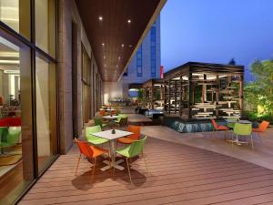 新德里ibis New Delhi Aerocity - An Accor Brand的大楼内带桌椅的阳台