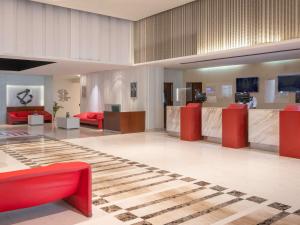 新德里ibis New Delhi Aerocity - An Accor Brand的大堂设有红色家具和 ⁇ 板地板