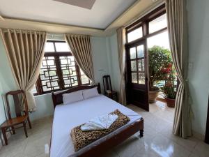 邦美蜀Manh Hung Hotel的一间卧室设有一张床和一个大窗户