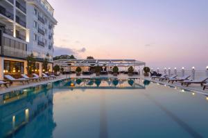 吉雷松La Quinta by Wyndham Giresun的酒店游泳池设有椅子,酒店大楼