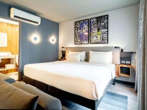 圣保罗Novotel SP Jardins的卧室配有一张白色的大床和一张沙发。