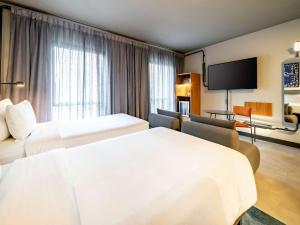 圣保罗Novotel SP Jardins的酒店客房设有两张床和一台平面电视。