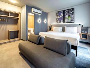 圣保罗Novotel SP Jardins的一间卧室配有一张大床和一张沙发