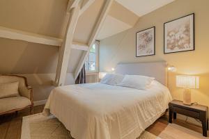 贡比涅LE MOULIN DE L'ORTILLE的卧室配有白色的床和椅子