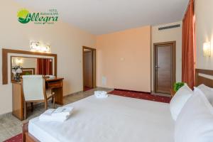 金沙Hotel Allegra Balneo & SPA的酒店客房设有一张白色大床和一张书桌