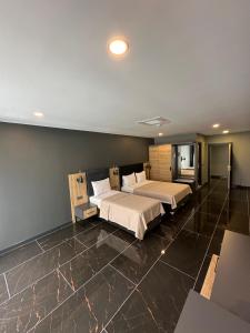 PelitliBurç Otel的一间带两张床的卧室和大型瓷砖地板