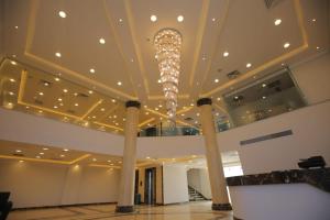 Qaryat ash ShamālīGrand Plaza 6 Octobar的大楼内带吊灯的大型大堂