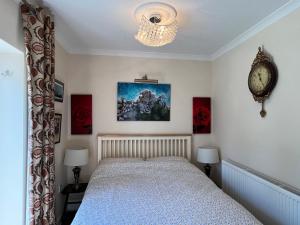 温莎Private Apartment in Windsor的卧室配有一张床,墙上挂着一个钟