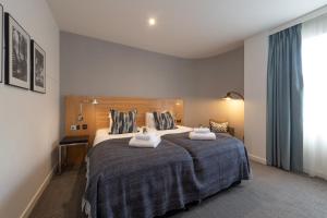 爱丁堡派克斯爱丁堡城市酒店的一间卧室配有一张大床和两条毛巾