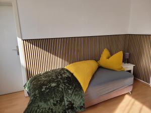 诺因哈根Carl-Schmäcke-Straße 7的一间卧室配有一张带黄色枕头的床