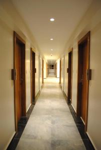 拉特纳吉里Hotel Landmark Ratnagiri的一条空的走廊,有门,有长长的走廊
