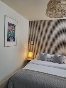 邓加文360 Town Stay Apartments & Studios的卧室配有一张床,墙上挂有绘画作品