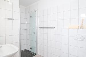 上陶恩alpsrental Apartments Freja Obertauern的带淋浴和盥洗盆的白色浴室