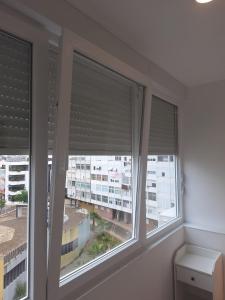 阿尔马达Lisbon South Bay Rooms 2的一间设有三扇窗户的房间,上面有百叶窗