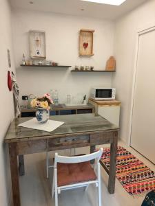 卡莱扎诺La petite suite的厨房配有带花瓶的木桌