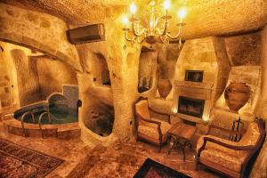 格雷梅旅行者洞穴宿舍酒店的客厅设有壁炉和吊灯。