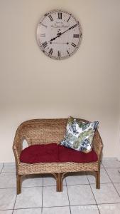 希俄斯Διαμέρισμα στο Κέντρο της Χίου的挂在柳条沙发上墙上的时钟