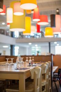 蒙热内夫尔Villages Clubs du Soleil - MONTGENEVRE的餐厅里一张桌子,椅子和灯