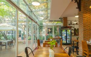 金边Skyline Boutique Hotel Phnom Penh的温室设有木桌和玻璃墙