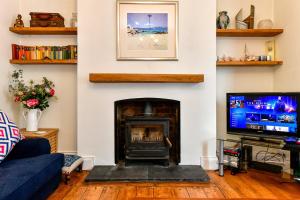 马伯斯Beautiful family home in Mumbles, with garden的客厅设有壁炉和电视。