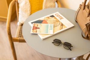 尼斯Nice Pam Hotel Fully Renovated的一张桌子,上面有杂志和眼镜