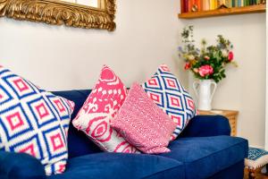 马伯斯Beautiful family home in Mumbles, with garden的蓝色的沙发,上面有枕头,镜子