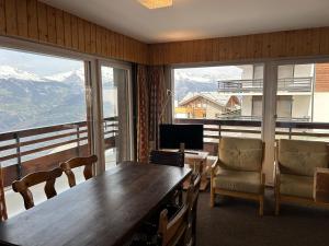 韦松纳Diablerets SKI LIFT & MOUNTAIN apartments的一间带桌椅和窗户的用餐室