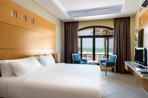 沙迦Occidental Sharjah Grand的酒店客房,配有床和电视