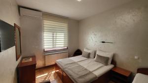 弗尔尼亚奇卡矿泉镇Dukat Apartmani-Studio的一间小卧室,配有床和窗户