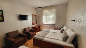 弗尔尼亚奇卡矿泉镇Dukat Apartmani-Studio的一间小卧室,配有一张床和一把椅子