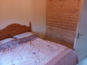 戈里Kilcavan Chalet的一间卧室配有一张木墙床