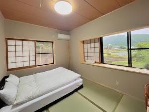 由布市湯布院我楽珍民泊Yufuin Garakuchin的小房间设有床和2个窗户