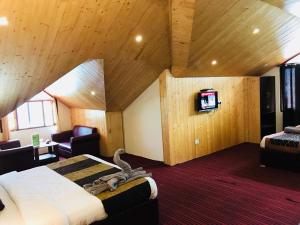 萨哈兰普尔Shunye lodge的酒店客房设有一张床和一台电视。