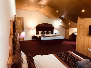 萨哈兰普尔Shunye lodge的一间带两张床的卧室,位于木天花板的房间