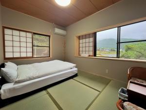 由布市湯布院我楽珍民泊Yufuin Garakuchin的带窗户的客房内的一张床位
